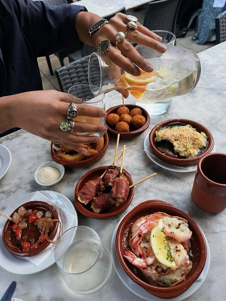 Selezione di tapas con pancetta, polpette, gamberi e cocktail alla frutta per l'aperitivo in Isola Milano